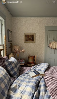 a bed room with a neatly made bed next to a window and a painting on the wall