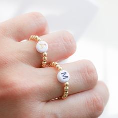 Beautiful beaded Ring with acrylic letters strung on an elastic cord. C U S T O M I N I T I A L ∙ R I N G ----------------------♡--------------------- M A T E R I A L S: * Ball: 18k Gold Plated over Brass * Beads gold: 3 mm * Letters: 7mm * It is made with stretchy elastic string that is very good quality!! -----------------------♡-------------------- SIZE * Adjustable Range US 6 - 8 - 9 ------------------------♡-------------------- H O W T O O R D E R 1.) Choose the Option in the drop down menu Trendy Round Jewelry With Letter Beads, Adjustable Initial Ring, Minimalist Jewelry With Letter Round Beads, Minimalist Jewelry With Round Letter Beads, Minimalist Letter Beads Jewelry For Friendship, Adjustable White Initial Ring As A Gift, Adjustable White Initial Ring Perfect For Gifts, Minimalist Personalized White Initial Ring, Gold Letter Necklace