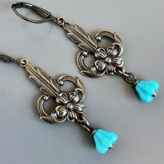 "Turquoise Flower Earrings - Small Turquoise Czech Glass Flowers dangle from Ornate Antiqued Brass Flower stampings that have a lot of detail. The stamping charms have hollow backs and are lightweight. The earrings measure  just over 1.75\" from top of earwires to bottom  Antiqued Brass Leverback Earwires" Vintage Flower Charm Dangle Earrings, Vintage Dangle Earrings With Flower Charm, Vintage Drop Earrings With Flower Charm, Vintage Turquoise Flower Earrings, Vintage Turquoise Dangle Flower Earrings, Vintage Blue Flower Earrings, Nickel-free, Turquoise Flower-shaped Earrings With Flower Charm, Turquoise Earrings With Flower Charm, Vintage Blue Flower Earrings Nickel Free