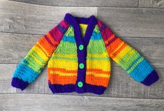 a colorful knitted cardigan sitting on top of a wooden floor