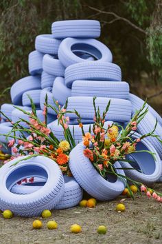 a bunch of tires stacked on top of each other in front of flowers and lemons