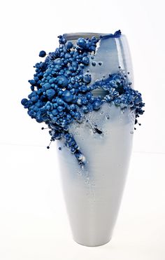 a blue and white vase filled with lots of small balls on top of it's sides