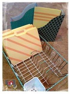 several folders are stacked on top of each other in a wire basket with blue handles