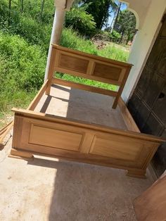 a wooden bed frame sitting on top of a cement floor