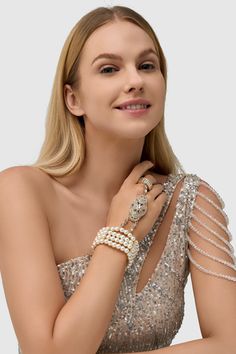 This sumptuous piece of jewelry features a retro-elegant yet slightly modern style that complements the lavish garments, reminiscent of the roaring 1920s. Features: High quality Austrian crystals and imitation pearls Four strand design Inner perimeter of bracelet is 7.4"/ 18.8cm Diameter of ring: 0.7"/ 1.78cm Glamorous Jeweled Bracelets For Party, Glamorous Pearl Chain Jewelry For Party, Glamorous Party Bracelet Jewelry, Glamorous Party Pearl Chain Jewelry, Glamorous Pearl Jewelry For Formal Occasions, Elegant Metal Bracelets With Bling, Luxury Silver Beaded Bracelets For Party, Elegant Metal Bracelet With Bling, Elegant Crystal Bracelets With Jewels