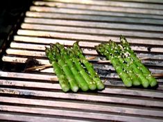 asparagus are being cooked on the grill with little oil sprinkles