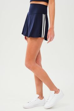 Side view of girl wearing dark blue upper thigh skirt with built in shorts, with two white stripes down the side and white shoes Stripe Fashion, Keds Style, Pickleball Court, Tennis Skirts, Spin Class, Tennis Skirt, Super Powers, Gym Workouts, Athleisure