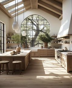 a large kitchen with lots of counter space and wooden flooring, along with an arched window