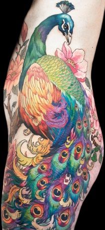 a woman's thigh with a peacock tattoo on it