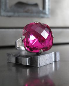 "LIMITED EDITION! Gorgeous, saturated juicy color! This crystal cocktail ring features a mouthwatering, intensely sparkling, rich magenta Swarovski crystal. This rare & out-of-production, cushion-cut Swarovski crystal is set into an elegant & modern antiqued silver plated bezel on an adjustable ring band (fits approx sizes 6 to 9) -LIMITED EDITION design -Rare, out-of-production Swarovski crystal -Cushion-cut Swarovski crystal: 16mm dia (11/16\") -Antiqued silver plated adjustable ring - Magenta Crystal, Monogram Ring Gold, Color Changing Ring, Ancient Coin Jewelry, Opal Solitaire Ring, Magical Accessories, Raw Crystal Ring, Swarovski Crystal Rings, White Opal Ring