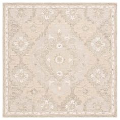 a beige and white rug with an intricate design on the bottom, in front of a white background