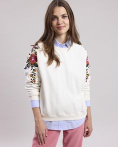 Women's round-neck sweatshirt in soft fleece. Raglan sleeves with floral border details on the shoulders. Ribbed edges on the collar, sleeves and bottom of the garment. Brushed interior. Cream Long Sleeve Tops With Embroidered Sleeves, Cream Tops With Embroidered Long Sleeves, White Floral Embroidered Sweatshirt For Fall, Leopard Jacket, Perfect White Tee, White Fleece, Round Neck Sweatshirts, Sweatshirts Online, Floral Border