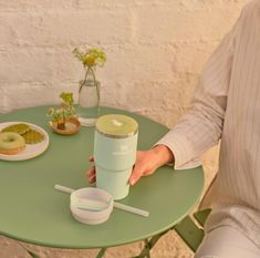 a person sitting at a table with a cup and donut