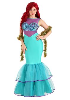 a woman in a mermaid costume is standing with her hands on her hips and looking at the camera