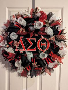 a wreath with the letters fraternity and an o on it hanging on a white door