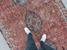 a person standing on top of a rug with their feet up in the air,