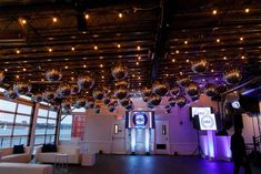 a large room with lots of shiny balls hanging from the ceiling and lights on the walls