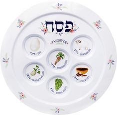 the passover plate has seven plates with different food items on it and hebrew writing