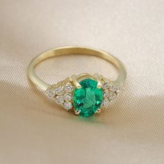 "Handmade by an inspired jewelry artist team with decades of experience in the craft of jewelry making. Each gemstone, each diamond is carefully picked. Using only the finest raw materials and the highest industry standard in manufacturing, design and finish. Emerald oval gemstone and diamonds 14K gold ring. showcasing a beautiful oval cut Colombian Emerald. Engulfed on both sides with white diamond full of fire and sparkle. Gemstone info: ------------------------------ √ Oval cut, prong set. Co Oval Emerald Ring With Diamond Accents, Exquisite 14k Gold Emerald Ring With Center Stone, Oval Emerald Ring With Diamond Accents For May Birthstone, Oval Emerald Ring In Yellow Gold With Prong Setting, Timeless Oval Emerald Ring With Diamond Accents, Exquisite Oval Emerald Ring With Diamond Accents, Oval Cubic Zirconia Emerald Ring In Fine Jewelry Style, Gold Oval Emerald Ring With Prong Setting, Promise Emerald Ring With Diamond Oval Shape