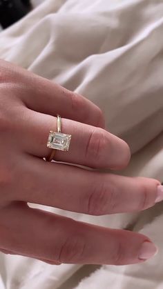 a woman's hand with a ring on it and a diamond in the middle