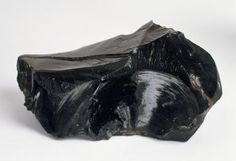 a piece of black rock sitting on top of a white table