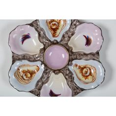 an image of a decorative plate with shells on the bottom and one shell in the middle