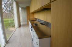 an empty kitchen with wooden cabinets and white appliances in front of a large sliding glass window