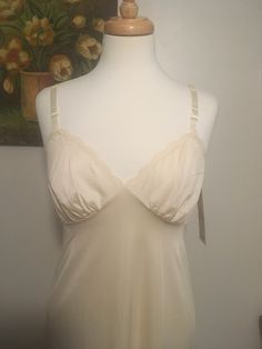 "Vintage new old stock Shadowline slip, 1950s beige slip dress, vintage full slip. Right out of the back storeroom! This new old stock unworn slip was in a ladies clothing store that had closed and has been sitting in the original box. The original tags are still attached. 'Pearl Beige' Bust x 34\" with adjustable straps to ensure a comfortable fit. Length x 48\" Beautiful silky Antron Nylon with a pretty delicate cross over neckline with lace around the bodice and bottom hem. New old stock in e Cream Camisole With Built-in Bra And Spaghetti Straps, Fitted Cream Camisole With Built-in Bra, Fitted Beige Camisole Dress, Fitted Beige Slip Dress With Lace Trim, Fitted Beige Lace Trim Slip Dress, Beige Spaghetti Strap Camisole For Daywear, Elegant Cream Camisole Slip Dress, Beige Lace Trim Camisole For Daywear, Elegant Beige Cami Intimate