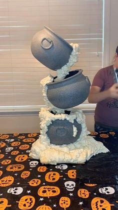 there is a cake made to look like a stack of pots with skulls on it