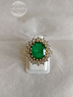 an emerald and diamond ring on a white background