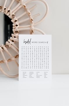 a white calendar sitting on top of a table next to a wooden chair and mirror