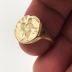 Meet The 14K Solid Gold Aequitas Ring Dainty and slightly fractured ancient coin engraved with Aequitas holding a cornucopia and a balance scale. Latin for truth and justice, The Veritus Aequitas Ring is designed as an amulet of protection and faith.A 14k solid gold signet ring set up with green emerald stone. This ring will be especially beautiful as a pinky ring will look great on any finger you choose to wear it. This minimalist cool, smooth and endless look ring is light and comfortable to w Antique Coin-shape Engraved Signet Ring, Antique Coin Shaped Engraved Signet Ring, Antique Engraved Coin Signet Ring, 14k Gold Byzantine Style Rings, 14k Gold Byzantine Round Ring, 14k Gold Byzantine Style Round Rings, Ancient Ceremonial Jewelry, Ancient Style Yellow Gold Signet Ring Gift, Gold Engraved Emerald Ring Gift