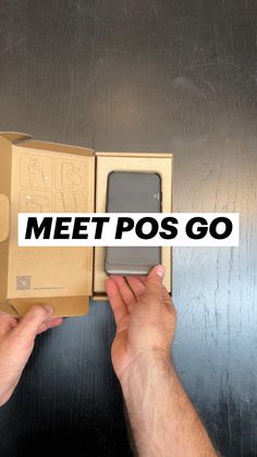 a person holding up a box with a cell phone in it that says meet pos go