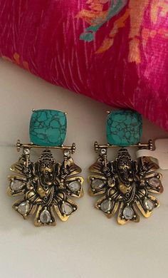 Embrace tradition with our Turquoise Antique Gold Ganesha Earrings, featuring intricate polki and feroza stones. These elegant temple jewelry pieces are perfect for Indian weddings and special occasions, adding a touch of spirituality and style to any outfit. Our products are meticulously handcrafted, ensuring each piece is unique. Due to the manual craftsmanship, you may notice slight irregularities, which are natural and do not compromise the quality of the jewelry. Indian Wedding Earrings, Ganesha Idol, Stones Earrings, Temple Jewelry, Earrings Antique, Indian Weddings, Antique Earrings, Temple Jewellery, Gold Plated Earrings