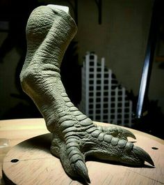 a fake alligator's foot sitting on top of a wooden table