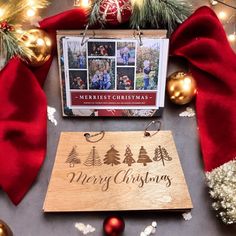 a wooden christmas card sitting on top of a table next to other holiday decorations and ornaments