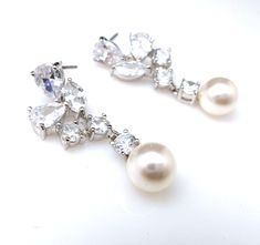 Tarnish resistant white gold plated metal framed multi shape clear quality cubic zirconia earrings with sterling silver post and white or cream swarovski 8mm round pearls. Luxury and elegant. Size: 2.8cm x 1.4cm Available in cream or white pearl Matching necklace and bracelet available. Please inquire. https://www.etsy.com/listing/255758756/bridal-bracelet-wedding-jewelry?ref=listings_manager_grid Looking for multi sets for your bridesmaid? Bracelet Wedding, Earrings Bridesmaid, Jewelry Bridal, Cubic Zirconia Earrings, Bridal Bracelet, Wedding Jewelry Earrings, Zirconia Earrings, Prom Party, Bridesmaid Earrings