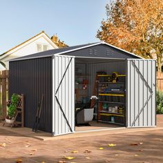 a shed with its doors open and tools in the storage area next to it on a patio