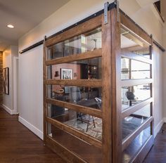 a room with a wooden floor and glass partitions on the wall to divide it from another room