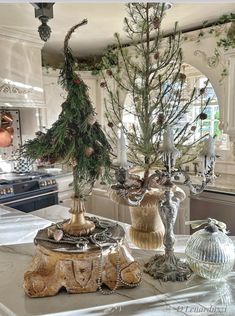 a table topped with vases filled with christmas tree branches and ornaments on top of it