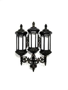 three black metal lanterns on a white background