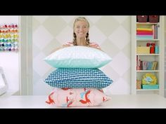 a woman sitting in front of a stack of pillows