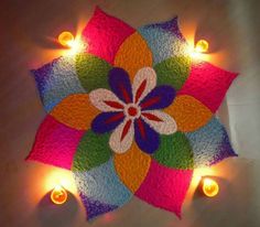 a colorful flower is lit up with candles