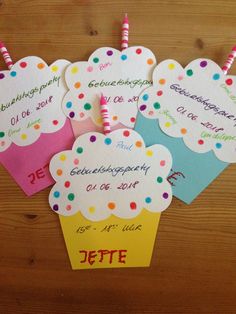 birthday cupcakes with name tags on them are displayed in front of a wooden table