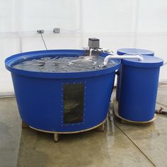 two large blue barrels with water in them