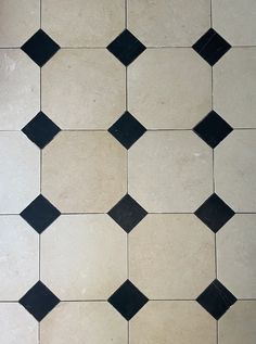 a white and black tiled floor with some black squares on the top right corner,