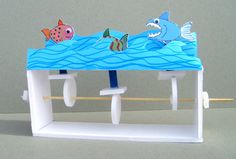 a toy boat with fish on the water