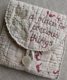 a piece of embroidered fabric with words on it and a button attached to the front