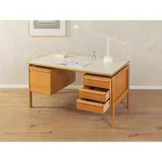 an office desk with two drawers and a lamp