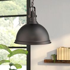 an industrial style pendant light hanging from a ceiling in a living room with a window